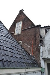 <p>In schoon metselwerk uitgevoerde 17e-eeuwse achtergevel van het rechter bouwdeel van Thorbeckegracht 12. In rood zijn de rijen klezoren gemarkeerd die de dagkant van verdwenen vensters op de verdieping en in de geveltop markeren. </p>
